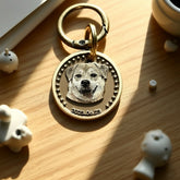 Gold keychain with a dog's face engraving on a wooden surface