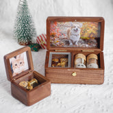 Two wooden jewelry boxes with pet photos and small bottles inside, on a white surface.