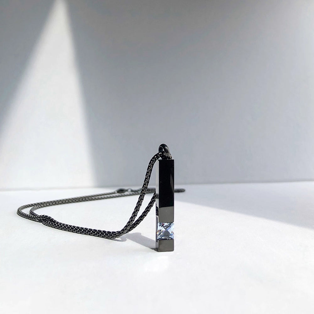 Necklace with a rectangular pendant on a white surface with a gray background