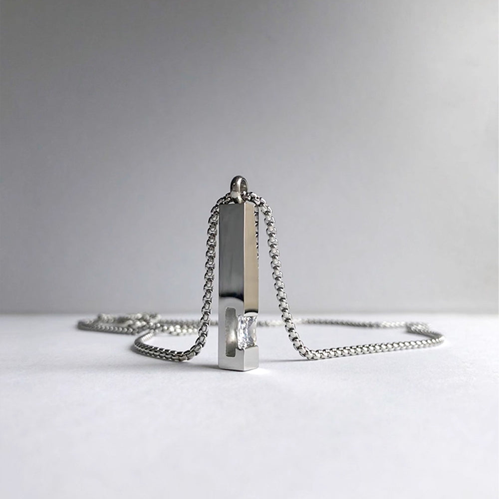 Silver necklace with a unique pendant on a light gray background