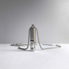 Silver necklace with a unique pendant on a light gray background