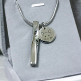 Silver necklace with a cat pendant on a gray background