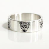 Silver ring with a wolf head design on a white background