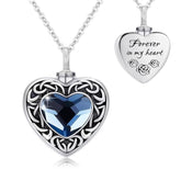 Heart-shaped silver pendant with blue gemstone and 'Forever in my heart' message on a white background
