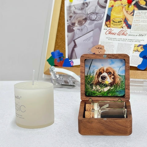 Wooden photo box with a picture of a dog on a table next to a candle.