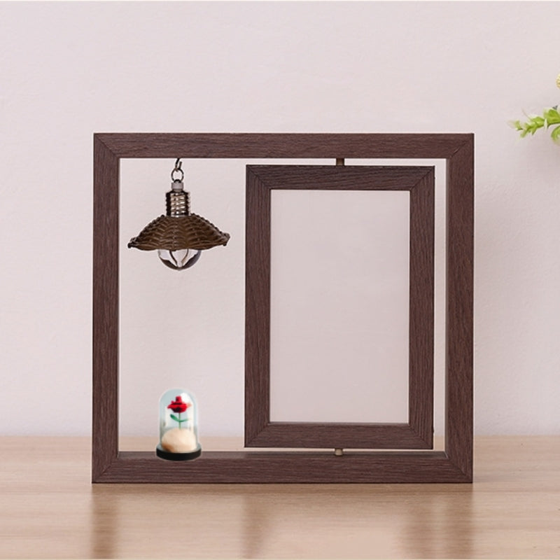 Wooden picture frame with decorative items on a light wooden surface and light pink background