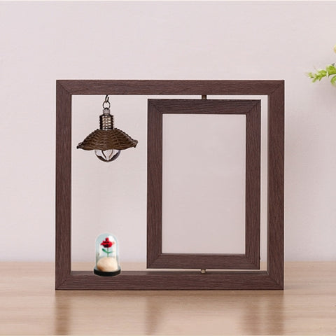 Wooden picture frame with decorative items on a light wooden surface and light pink background