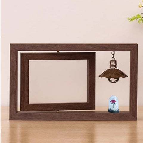 Wooden picture frame with a small decorative light bulb inside on a wooden surface.