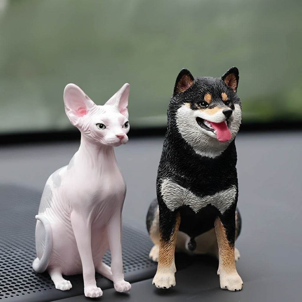 Two cat and dog figurines on a textured surface with a blurred background