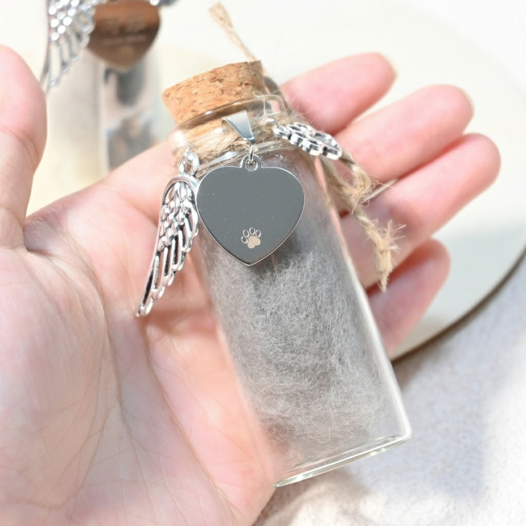 Heart-shaped pendant with wings in a clear bottle held by a hand