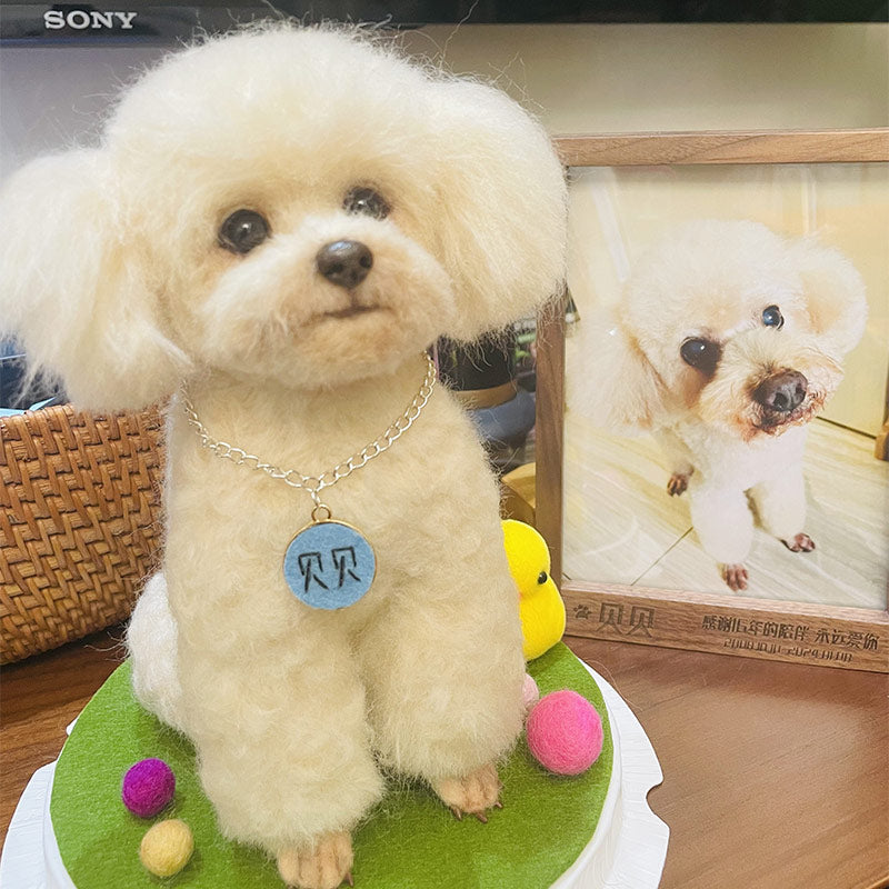 Small white dog with a blue tag on a green surface, with a framed photo of the dog in the background.