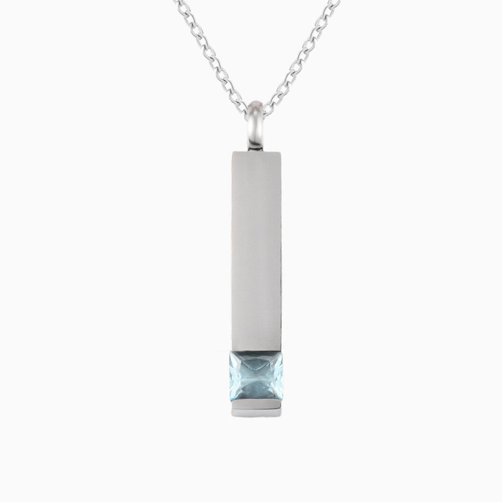 Silver necklace with a rectangular pendant featuring a blue gemstone on a white background