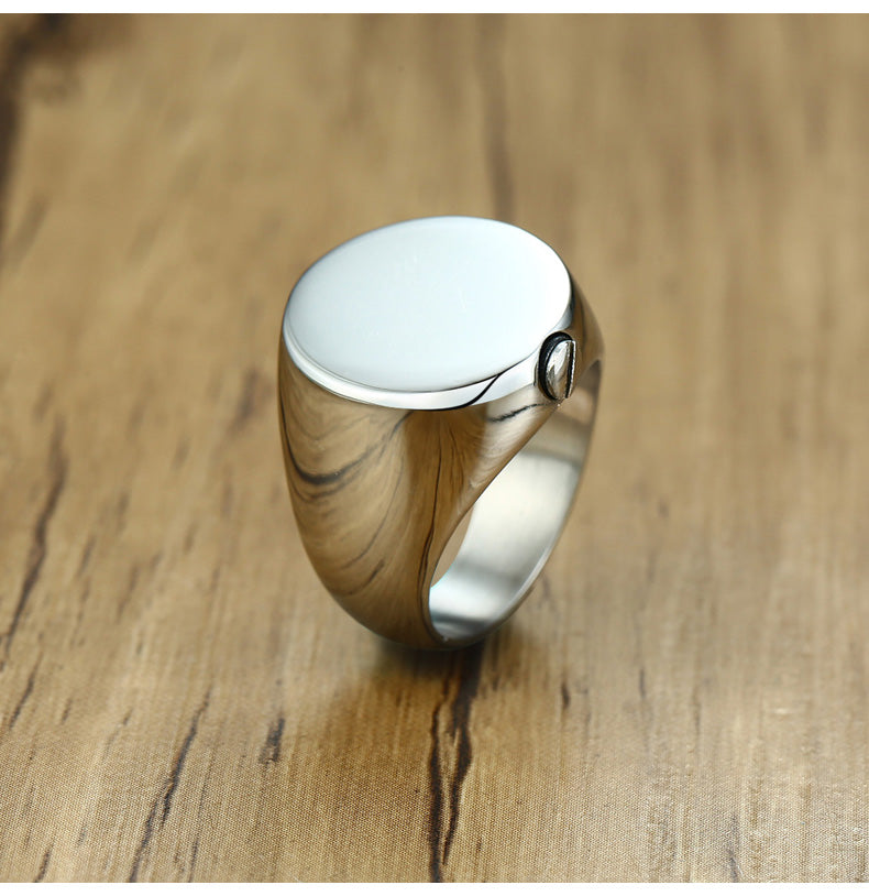 Silver ring with wooden band on a wooden surface