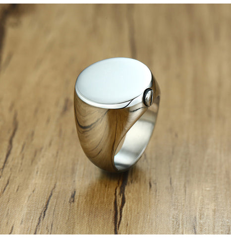 Silver ring with wooden band on a wooden surface