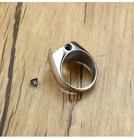 Silver ring with a small screw on a wooden surface