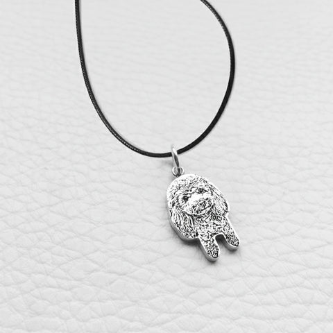 Silver Hamsa hand pendant on a black cord against a light gray background
