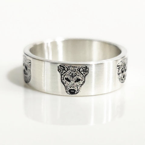 Silver ring with a wolf head design on a white background