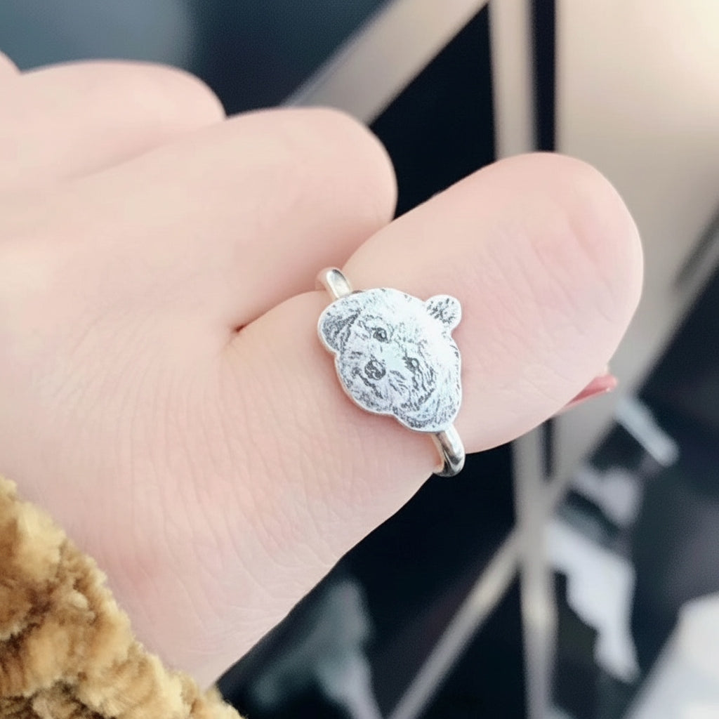 Silver ring with a bear design on a person's finger
