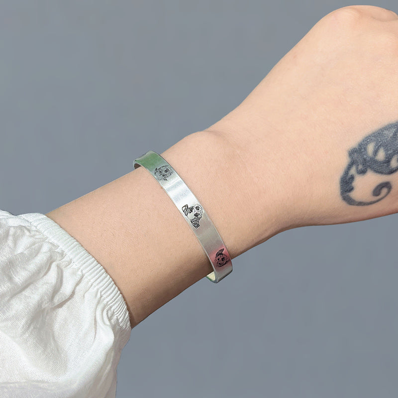 Silver bracelet on a wrist with a gray background