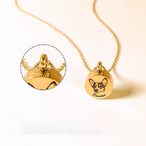 Gold necklace with pendant featuring a dog's face and engraved name on a white background