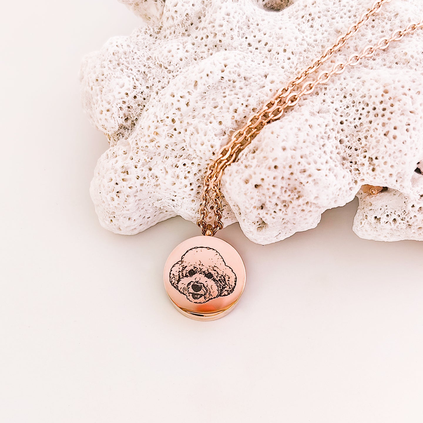 Rose gold necklace with a round pendant on a white background