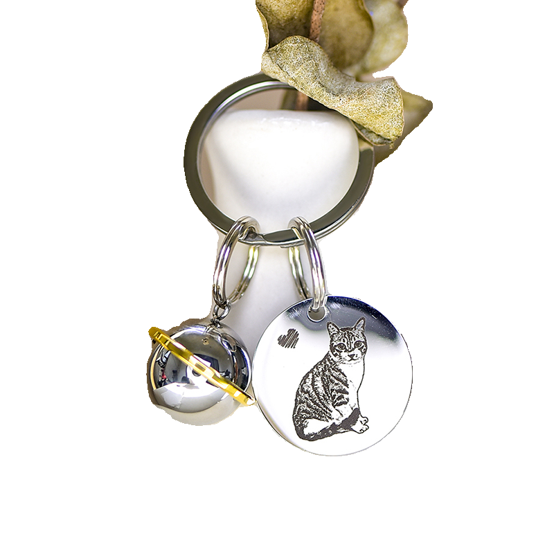 Keychain with a cat charm and bell on a white background