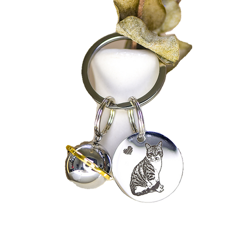 Keychain with a cat charm and bell on a white background