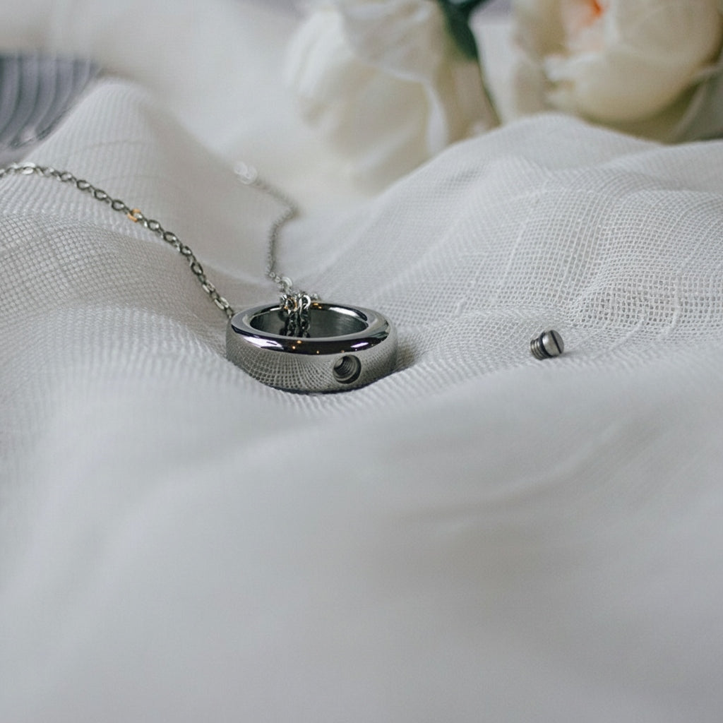 Silver necklace with a pendant on a white fabric background