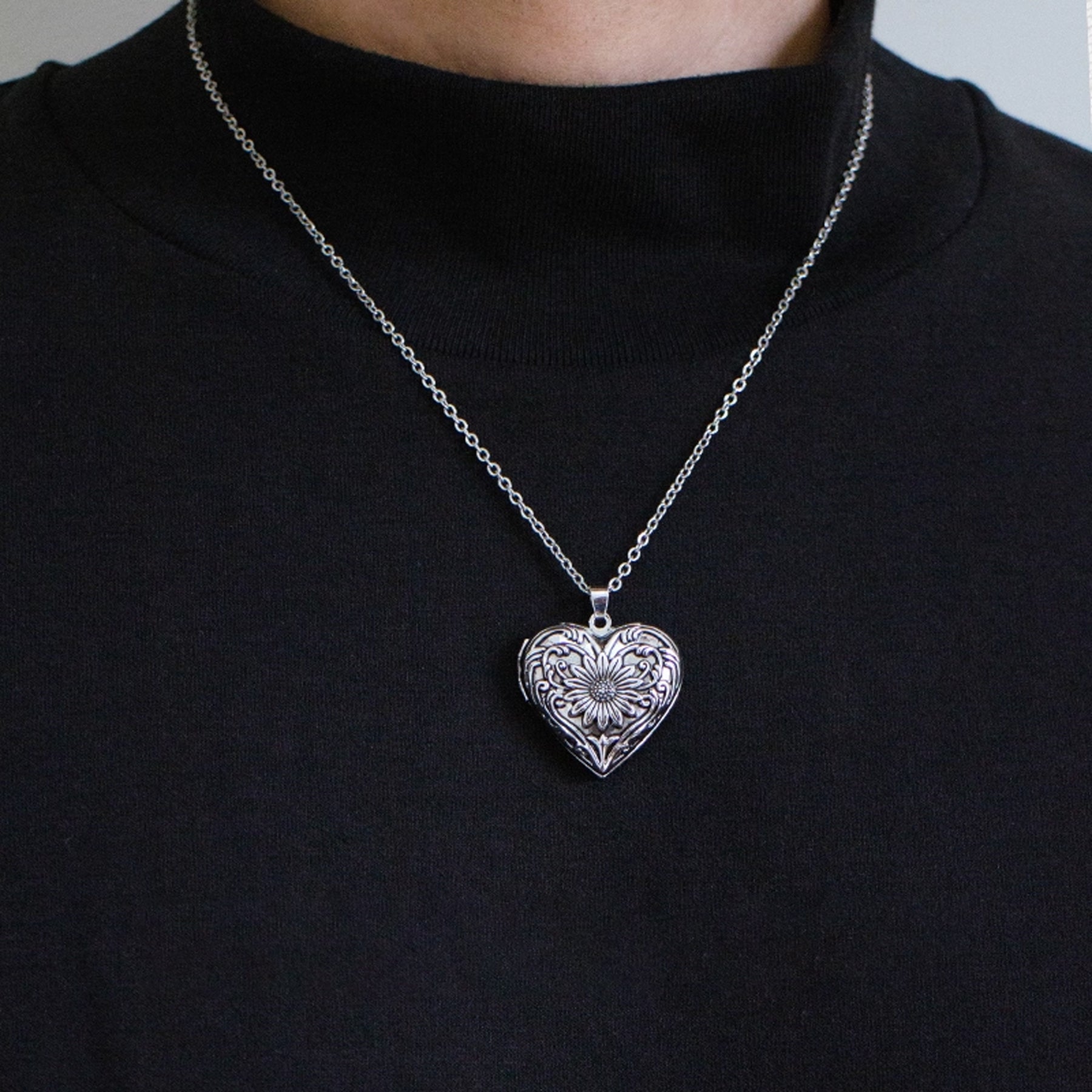 Silver heart-shaped pendant necklace on a black turtleneck