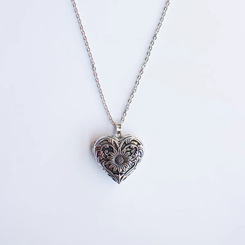 Silver heart-shaped pendant necklace on a white background