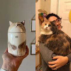 Cat-shaped container with a cat's face on it, held by a person, next to a person holding a real cat.