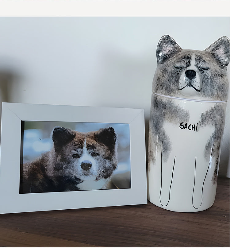 Dog-shaped container with 'Sachi' on a wooden surface next to a framed photo of a dog.