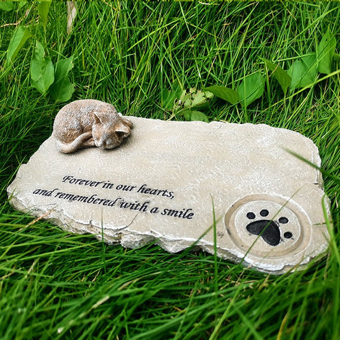 Memorial stone for a pet with text and paw print on grass