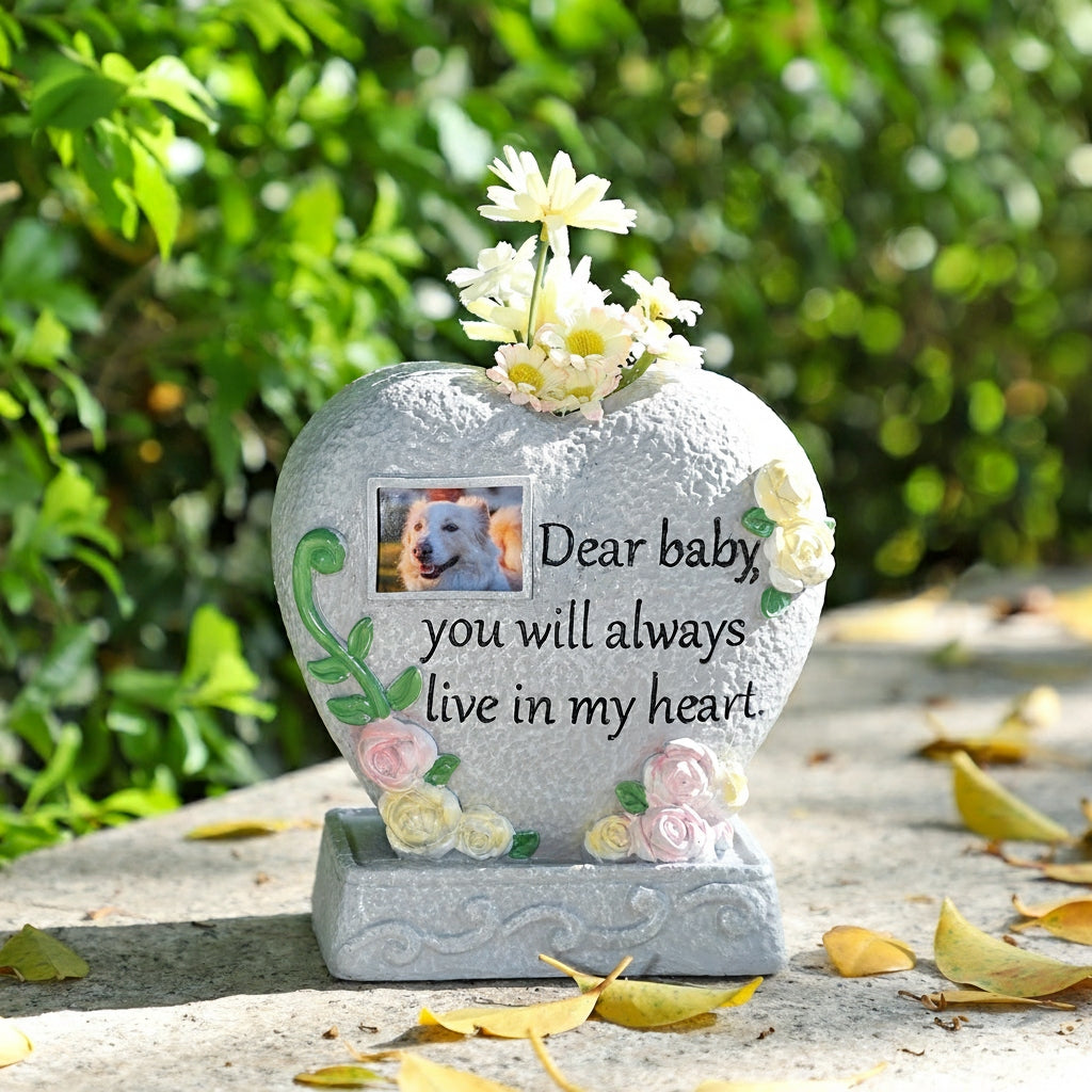 Memorial stone with flowers and a photo of a dog, set against a natural background.