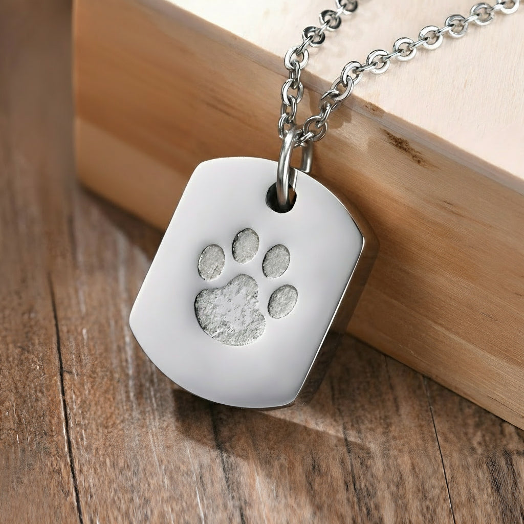 White dog tag with paw print design on a wooden surface