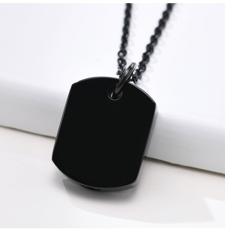 Black dog tag pendant on a chain against a white background