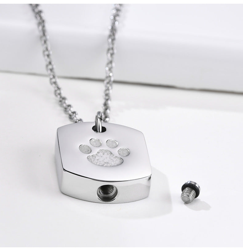 Silver pendant with paw print design on a white background