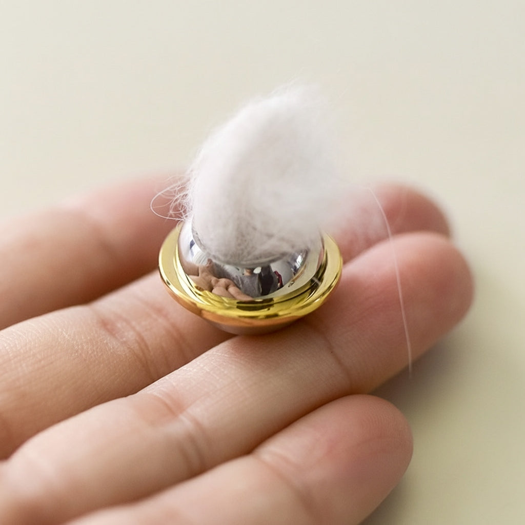 Gold and silver hair tie on a hand with a blurred background