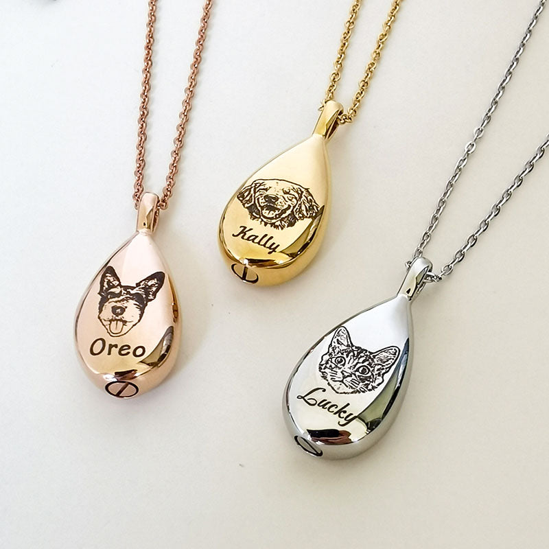 Three teardrop-shaped pet memorials with engraved dog portraits and names on rose gold, gold, and silver chains.
