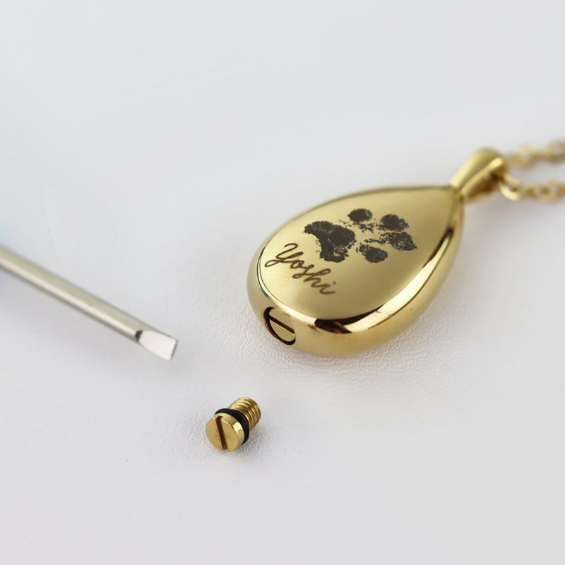 Gold teardrop-shaped pendant with paw print design and 'Joshi' engraving on a white background.
