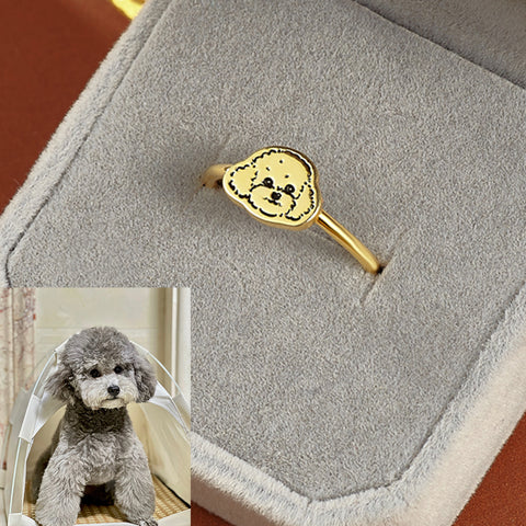 Gold ring with dog design in a gray box, with a small inset photo of a gray poodle.